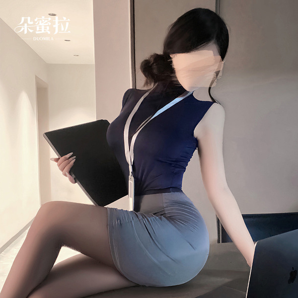 A woman wearing a navy blue sleeveless top paired with a form-fitting gray skirt sits on the floor holding a black folder. th...