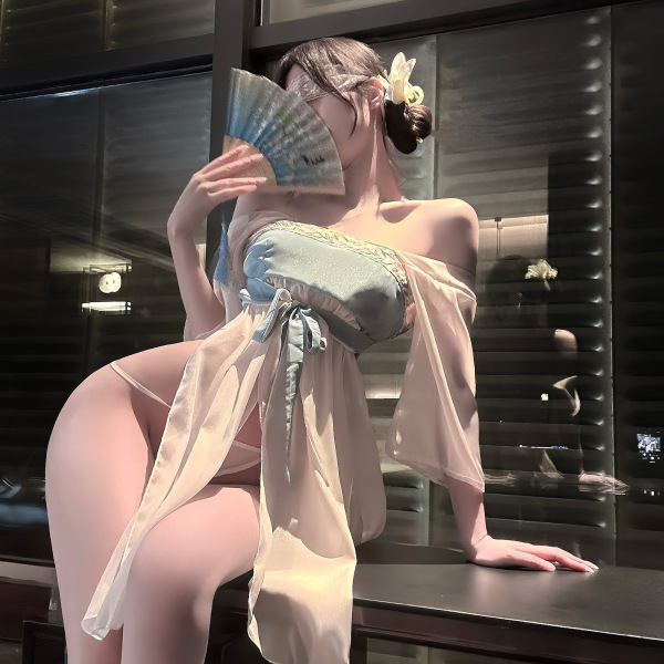 Woman wearing jinxiao lingerie set, elegant chinese-inspired silk babydoll and robe, holding a fan.
