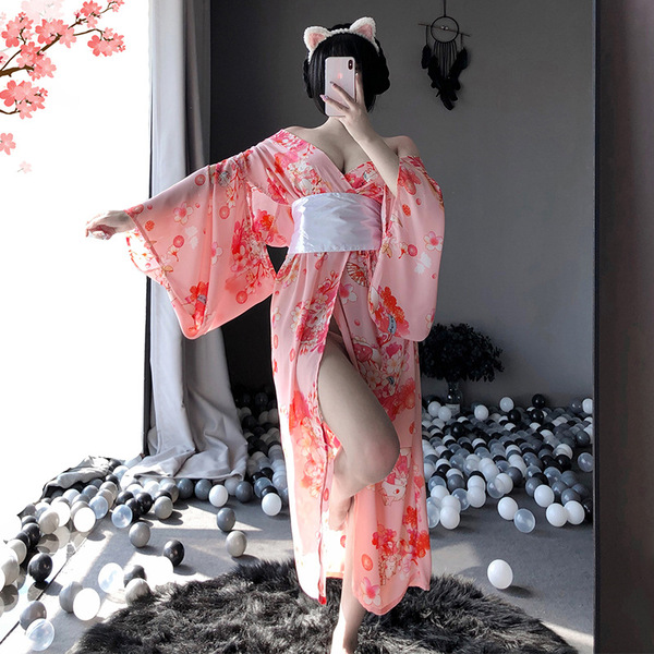 A woman poses in a pink floral japanese kimono-style cat-themed sleepwear set, featuring long sheer fabric and playful cat ea...