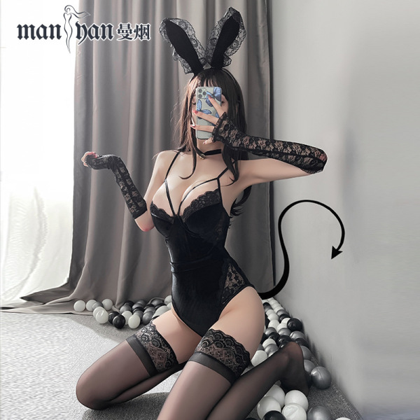 Woman in black velvet bunny lingerie set with lace gloves, thigh-highs, and tail, posing seductively for role play.