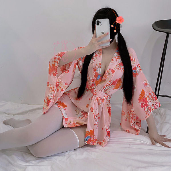 A person wearing a pink misty romance kimono lingerie set with floral patterns, posing while taking a selfie. the outfit feat...