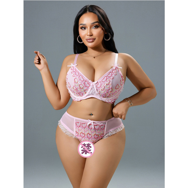 Woman modeling pink romantic lace lingerie set with floral sheer details, featuring bra and high-waist panties for date night...