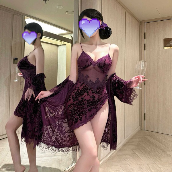 A woman poses in a luxurious purple floral lace bralette sleep set, featuring sheer cami and shorts, exuding elegance and com...