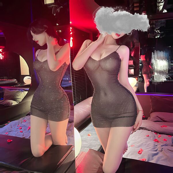 Woman wearing suoqing sexy v-neck low-cut lace sheer slip dress with full rhinestone embellishment, posing in a dimly lit roo...