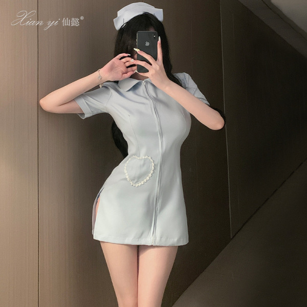 Woman wearing xianyi sexy nurse costume - light blue open-crotch cosplay lingerie with pearl heart detail, posing in mirror s...