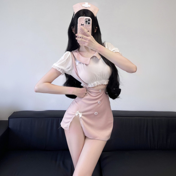 Woman modeling pink nurse-themed sultry sheer lace halter top set, featuring a cropped top and mini skirt with buttons, ideal...