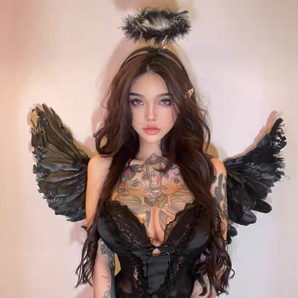 Woman wearing black lace lingerie set with feather wings and halo, elegant romantic sleepwear for couples.