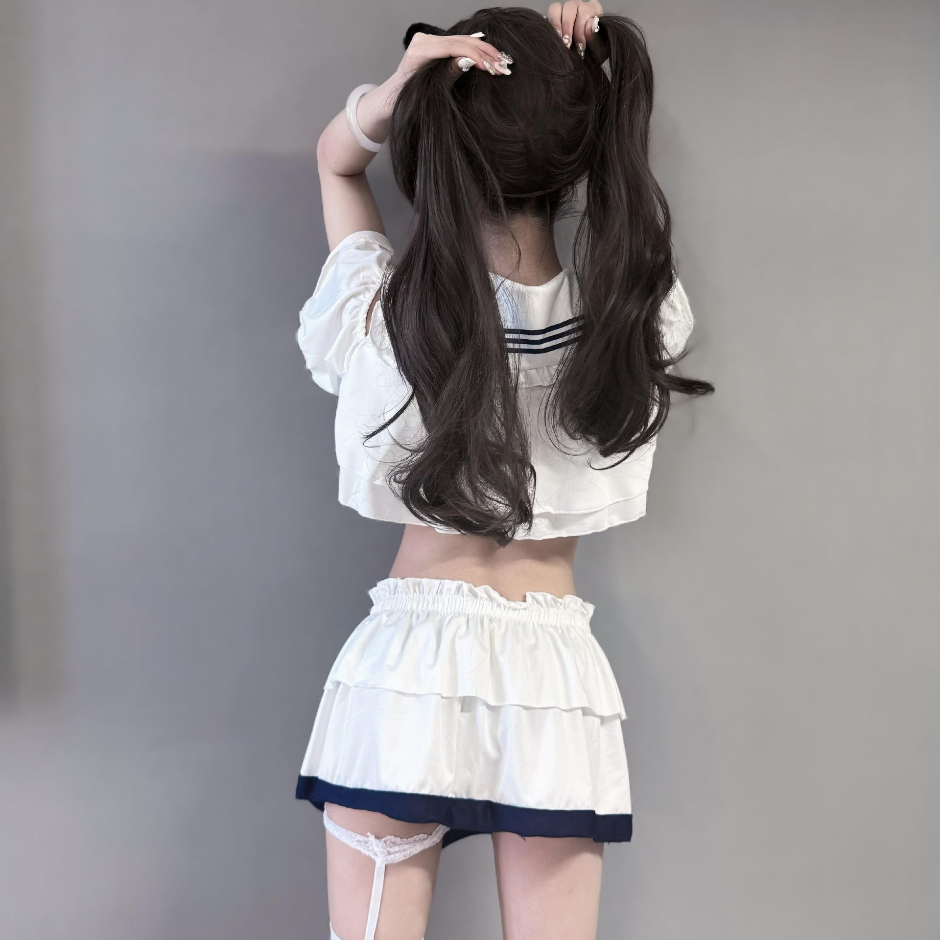 Seductive schoolgirl lingerie set featuring a white crop top with sailor stripes and layered skirt, perfect for passionate da...