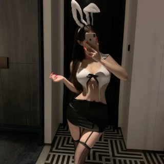 Woman wearing pure & alluring lingerie set with bunny ears, white top, black skirt, and thigh-high stockings in a mirror self...