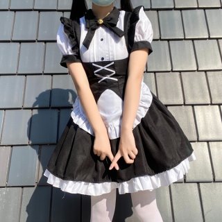 A woman wears a black and white gothic lolita maid dress with ruffles, buttons, and a bow tie, perfect for halloween costumes...