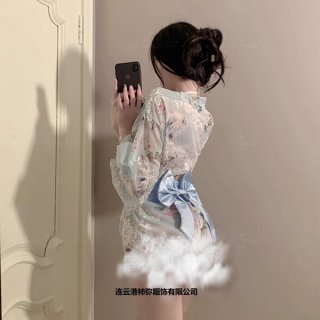 A woman models a delicate, floral-patterned kimono-style sleepwear set with a soft blue ribbon bow, exuding elegance and allu...