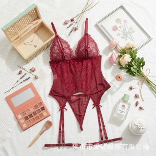 Red lace cami set with garter straps, styled as an elegant erotic bodysuit for women, surrounded by beauty accessories and fl...