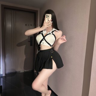 Woman modeling a white and black sailor-themed lingerie set with suspenders and pleated skirt, taking a mirror selfie in a st...