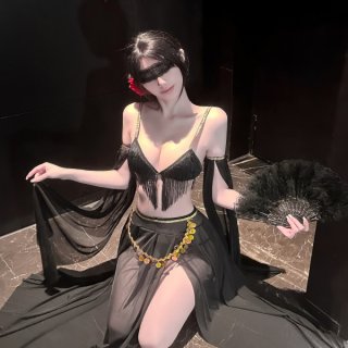 Woman in black fringed lingerie set with sheer skirt, gold coin belt, feather fan, and eye mask – luxury sensual lingerie for...