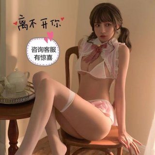 Woman in sexy bunny girl costume with pink bow, white lingerie, and thigh-highs, sitting on a wooden chair.