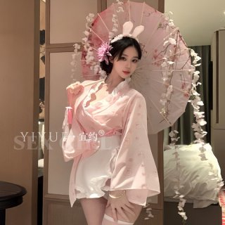 A woman poses elegantly in a pink japanese kimono-inspired costume, complete with bunny ears and floral accents, holding an o...