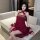 Woman wearing red sheer mesh cheongsam lingerie set with vintage bodice and matching jacket, seated on sofa.