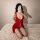 Woman modeling red sheer lace lingerie set on bed, showcasing plus size sexy sleepwear with delicate straps and sensual desig...