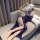 Woman reclining on sofa in elegant navy blue naben lace babydoll and chemise set, featuring delicate floral patterns and a mo...