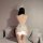 Woman wearing white bunny girl lingerie set with open-crotch design, sheer back, and fluffy tail detail.