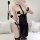 Woman modeling a sexy sheer lace bodysuit with clip-on neck strap, featuring black mesh, garter straps, and accessories for i...