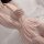 Woman wearing pink lace-trimmed sleep dress from pure & playful lingerie set, plus size flirty nightwear on white bedding.