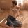 Woman wearing mannyan sheer mesh nightgown with vintage chinese qipao style, sitting on bed in soft light.