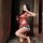 Woman in red nightsigh lace bodysuit posing with wine glass, sheer lace design, open-crotch style, sensual and elegant look.
