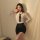 Woman modeling a seductive secretary costume set featuring a white blouse with deep v-neck, black tie, and high-waisted penci...
