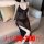 Woman wearing plus size deep v-neck sheer mesh nightgown, sitting on sofa. elegant black lingerie for women up to 200 lbs.
