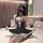 Woman in black cat-ear headband and sheer off-shoulder maid-style lingerie set with lace trim, seated on bed.