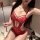 Woman wearing red lace bodysuit with sheer panels and thin straps, holding a decorative wand; plus size erotic lingerie for b...