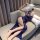 Woman lounging on sofa in deep blue lace slip dress with side slit, delicate trim, and sheer panels — modest yet alluring sle...