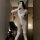 Woman in mirror wearing white open-crotch bodysuit with lace-top stockings, showcasing sexy lingerie set design.