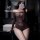 Woman modeling sheer mesh bodysuit with cut-outs in bathroom mirror selfie.