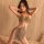 Woman wearing a sexy sheer lace bodysuit with sparkling sequins, perfect for nightclub outings or as seductive lingerie.