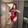 Woman in red bunny girl lingerie set with open-crotch design, holding plush toy, posing for mirror selfie.