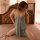 Woman wearing suoqing sexy lace sleep dress with adjustable straps and high slit, kneeling on bed in soft lighting.
