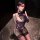 Woman in purple luxury lace satin lingerie set with underwire push-up bra and sheer thigh-high stockings, posing elegantly.