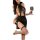 Woman in black sheer secretary bodysuit with skirt and fishnet stockings holding wine glass.