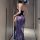Woman wearing a seductive lace lingerie set with sheer blue floral details and high slit, back view in hallway.