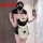 Woman wearing black and white plus size maid costume lingerie set with apron, bow tie, and garter straps for role play.