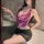 Woman wearing a purple secretary costume set with a bare-back top and high-waisted bodycon skirt, posing in a bathroom.