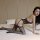 Woman wearing qingyege sheer mesh bodysuit with open crotch, posing on bed in black lingerie set for intimate nights.