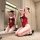 Woman kneeling in front of mirror wearing red plus size lace bodysuit sleepwear set with black heels, showcasing sexy yet mod...