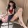A woman poses wearing a gufei sexy schoolgirl costume set, featuring a sailor top with a red bow, a short skirt, and thigh-hi...