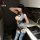 Woman wearing blue lace nightsigh nightseduce sheer mesh bodysuit with crotchless open design in modern kitchen setting.
