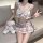 Woman in pure & playful jk sleepwear set, sensual roleplay lingerie with plaid bow top and skirt, holding teddy bear.