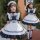 Japanese girl wearing a black maid dress with white accents, featuring ruffles and bows. cute lolita princess costume for kid...