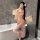 A woman poses in a bathroom wearing a night silk hanfu lingerie set, featuring a strapless cheongsam bodysuit with high slit ...